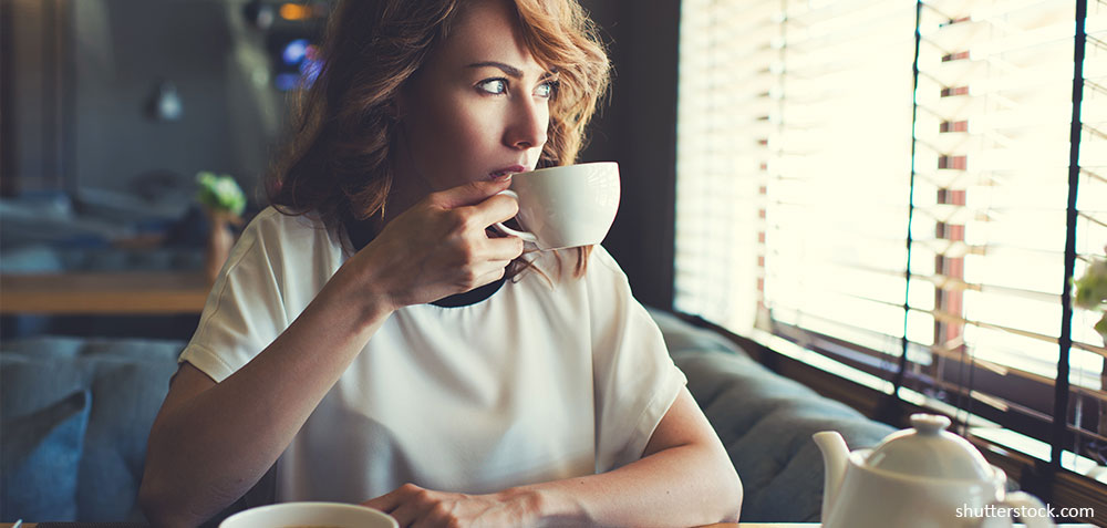 young-gorgeous-female-drinking-tea-and-thoughtfully-looking-out-of-the-coffee-shop